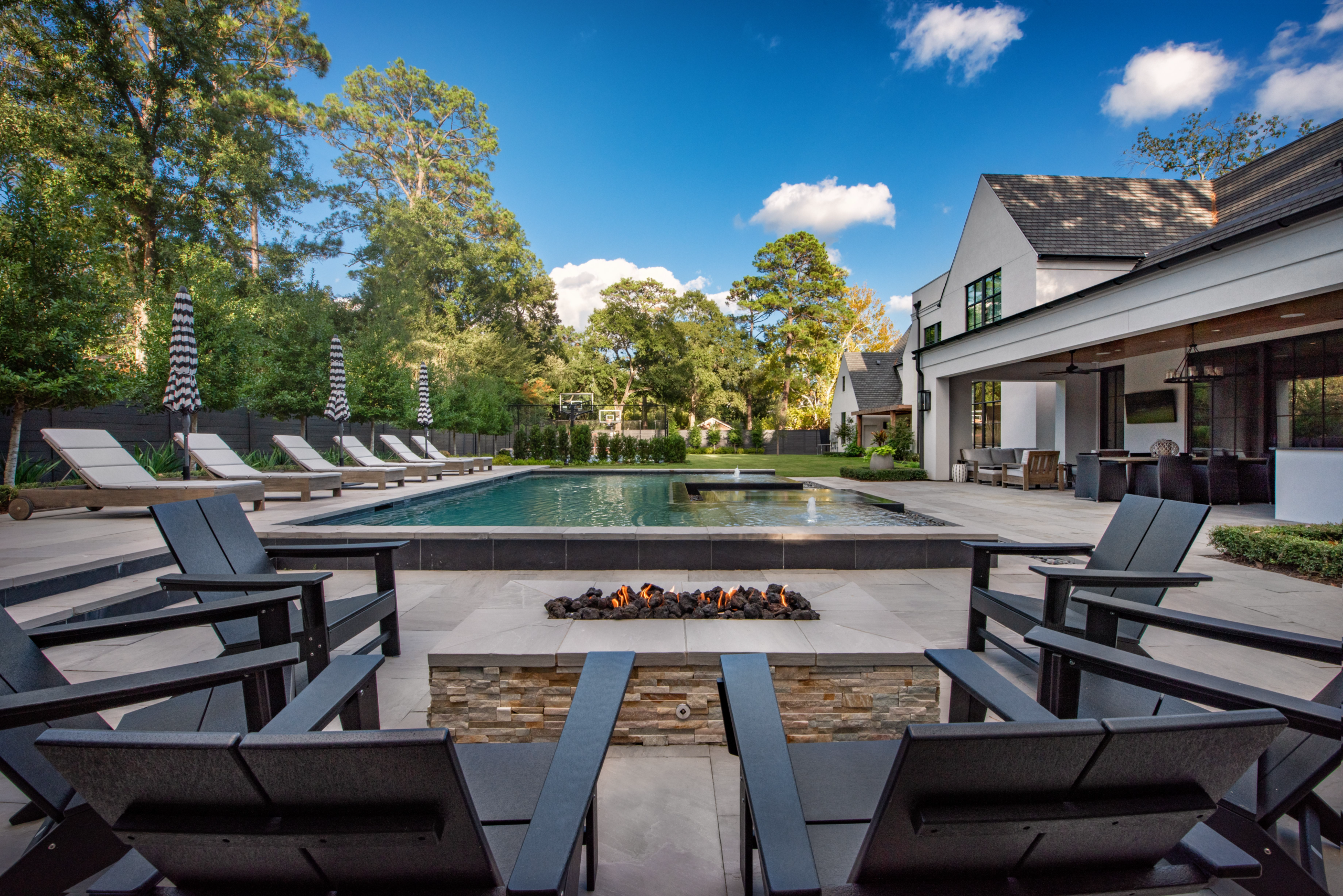 view of Adirondack chairs, firepit and pool