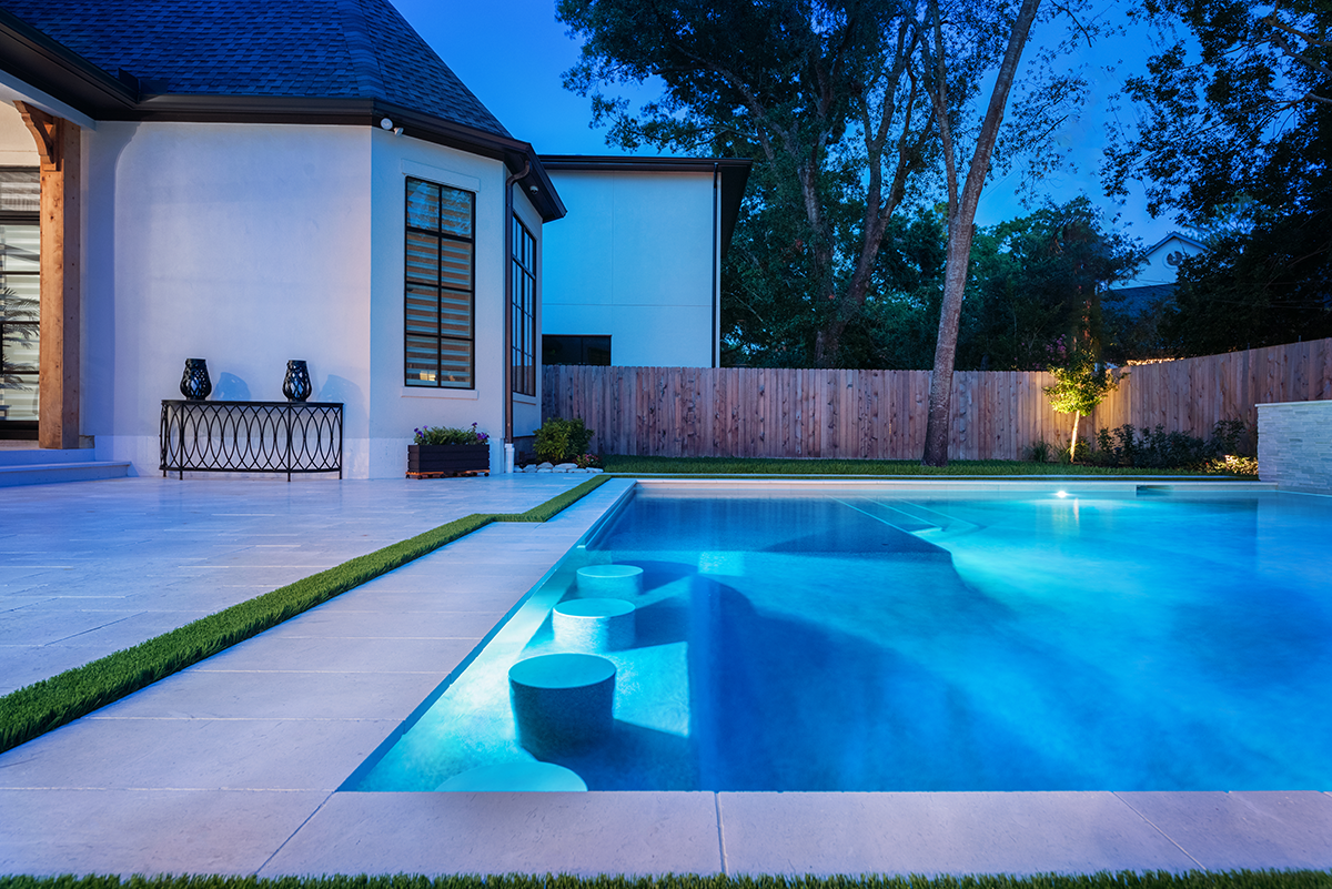 a pool with built in seating at night 