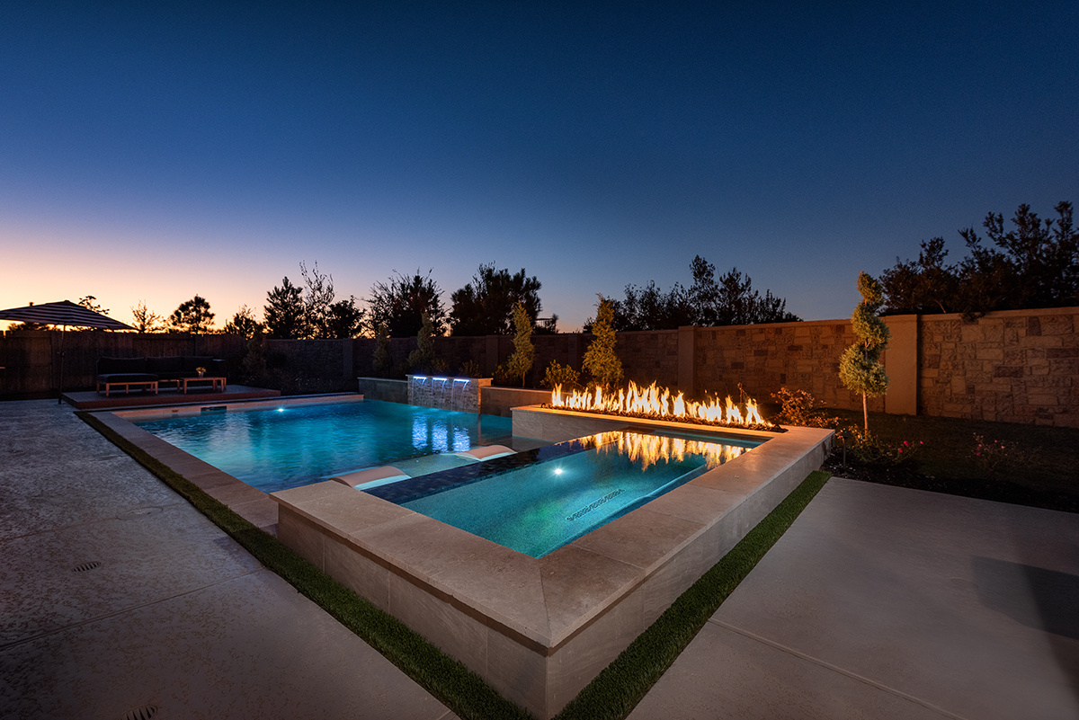 luxurious pool and spa with fire feature at night