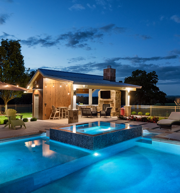 pool at night with seating area and cabana