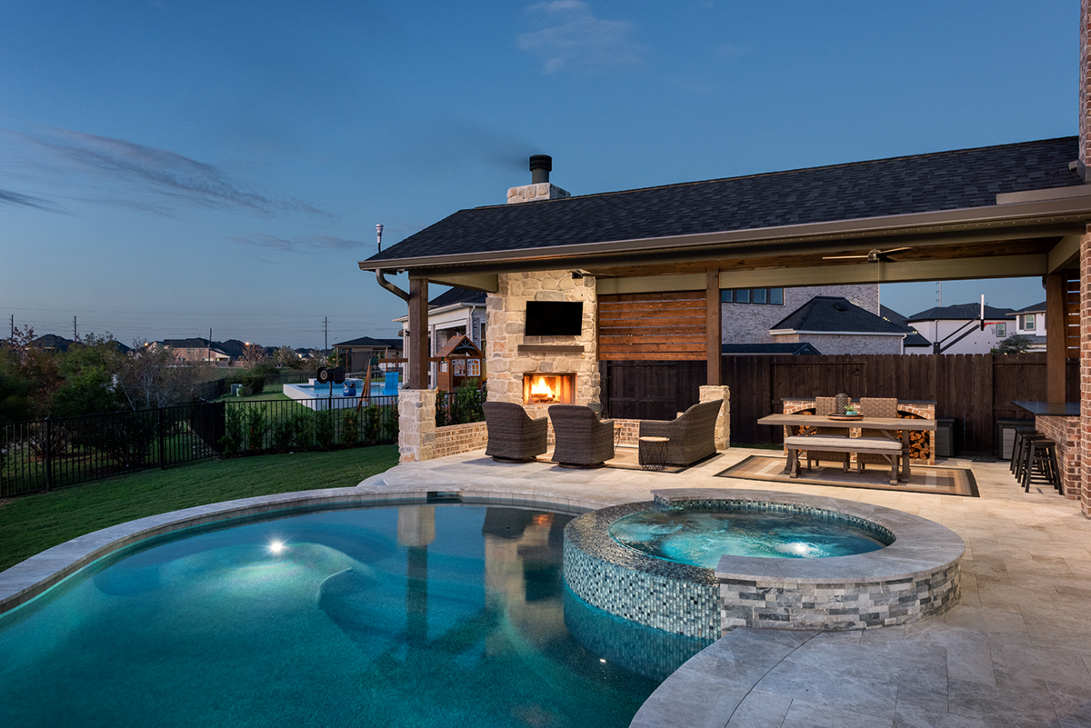 a pool and outdoor living area in the evening