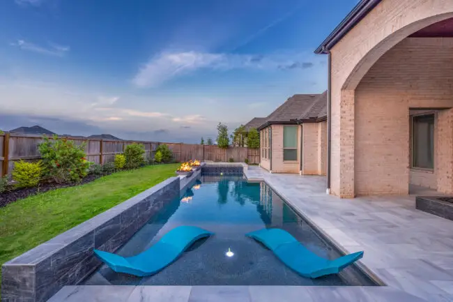 Custom-built pool with integrated fire features and modern landscaping