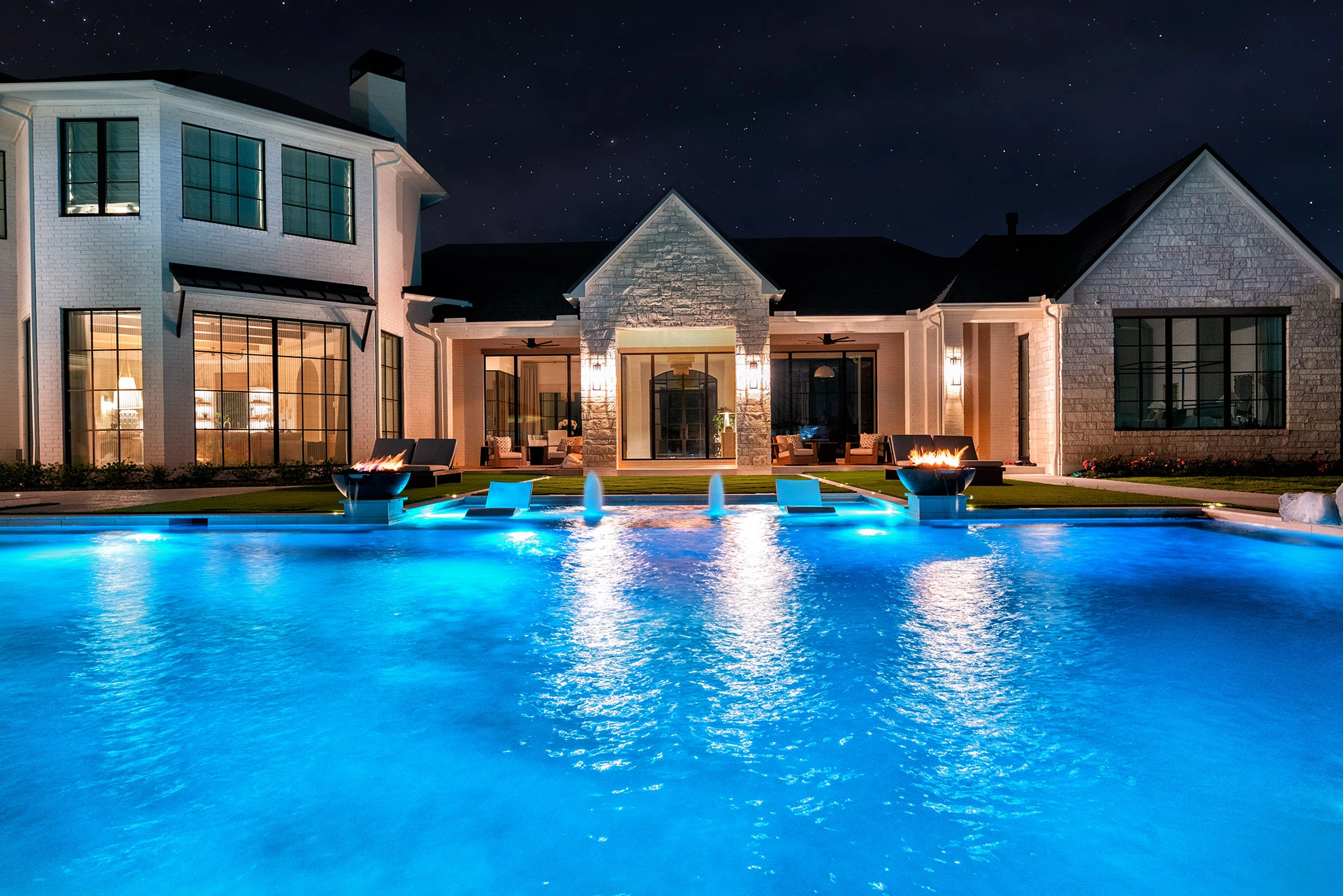 Modern pool with calm water and ambient fire lighting.