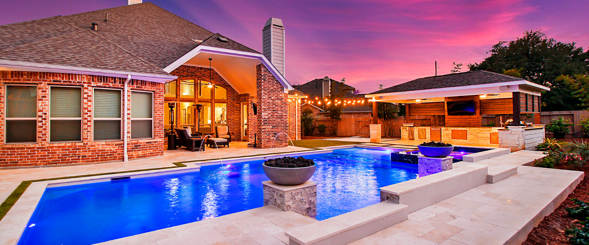 Renovated backyard featuring modern pool renovation ideas like LED lighting, fire bowls, and a pavilion.