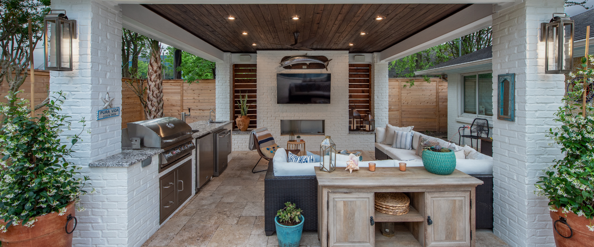 Resort-style outdoor living space featuring a covered patio, outdoor kitchen, and cozy seating area.